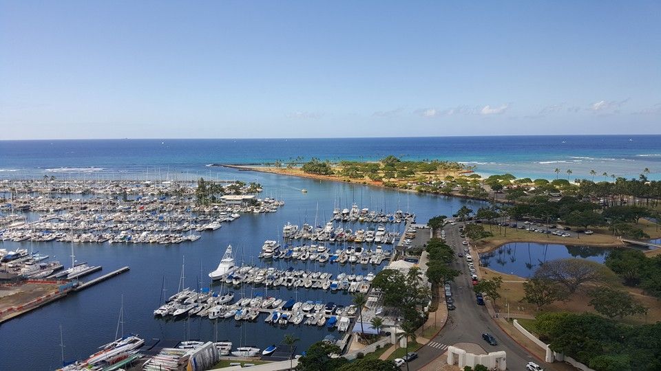 Boats in a harbor and turquoise water in Hawaii, seen from a high floor